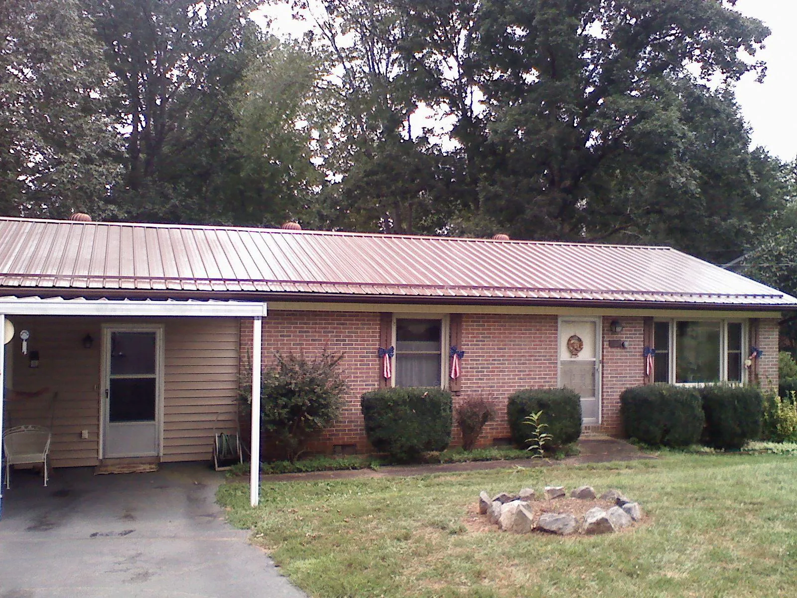 Bronze metal roof and carport on a brick ranch home — Roof Repair work by our crew in Audubon